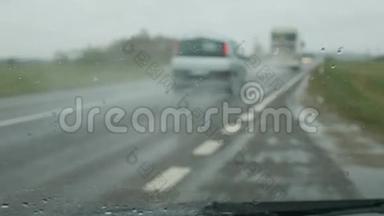 雨在汽车玻璃上倾泻而下。
